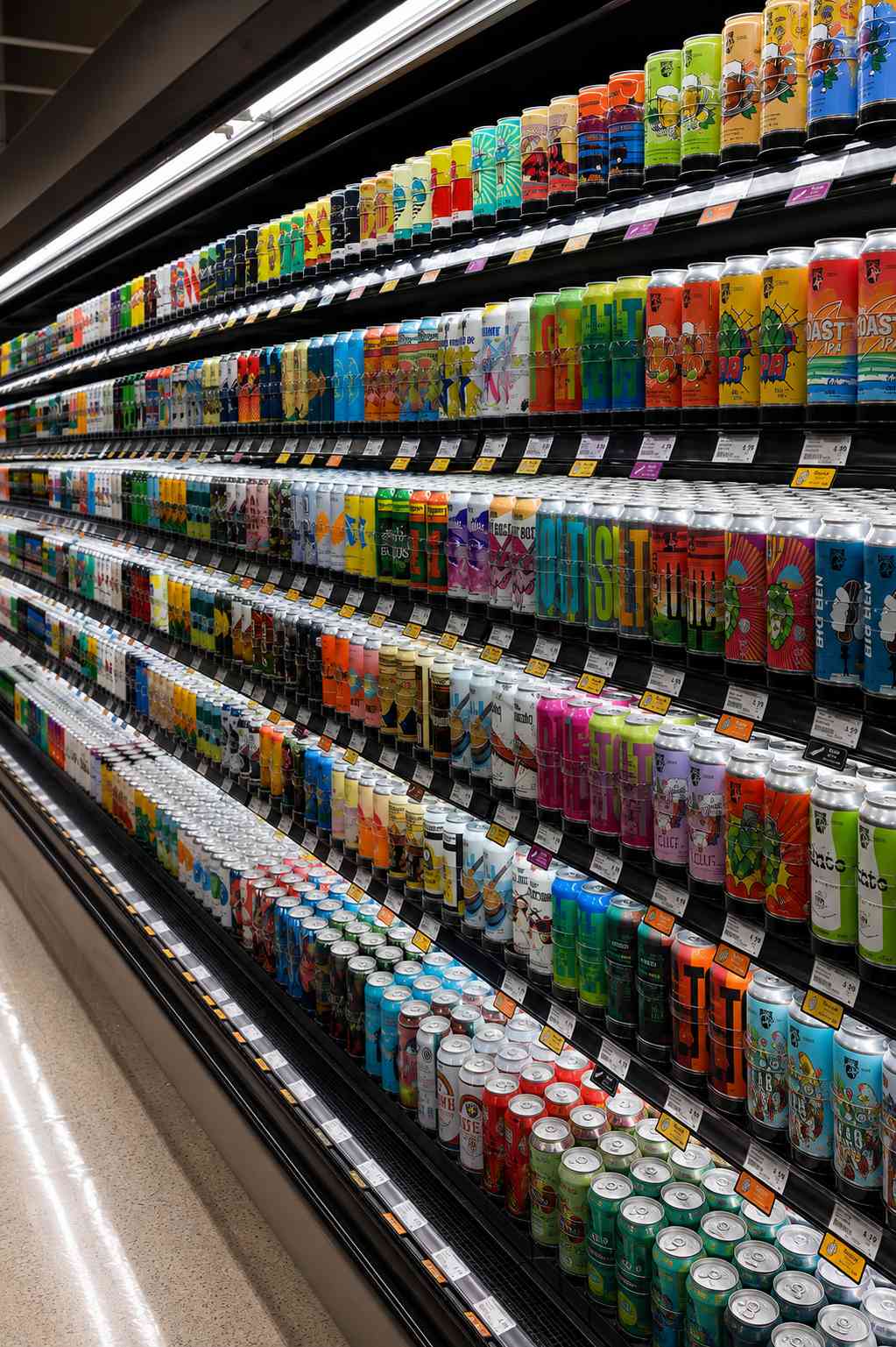 Longue allée réfrigérée d'épicerie en perspective, rangées de contenants alignés sur toute la longueur
