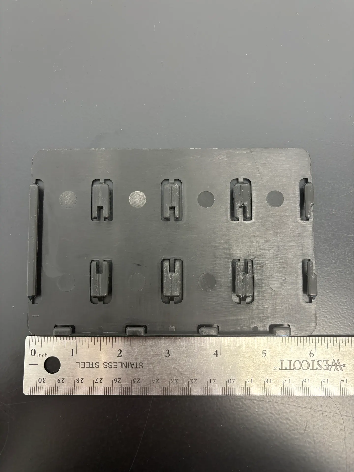 Plaque d'appui XXL noire vue de dessus — Poussoirs pour tablettes Robusta | Concept P.O.S. Seconde vue de la plaque d'appui XXL noire du Robusta, fentes et perforations de fixation bien nettes