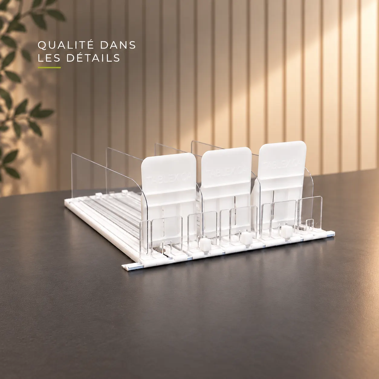 Poussoirs à tablettes blancs à séparateurs transparents sur une table sombre, titre « Qualité dans les détails »